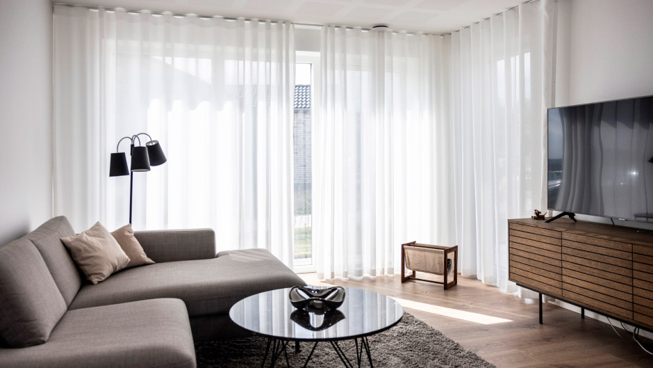 Hvide stofgardiner i stuen